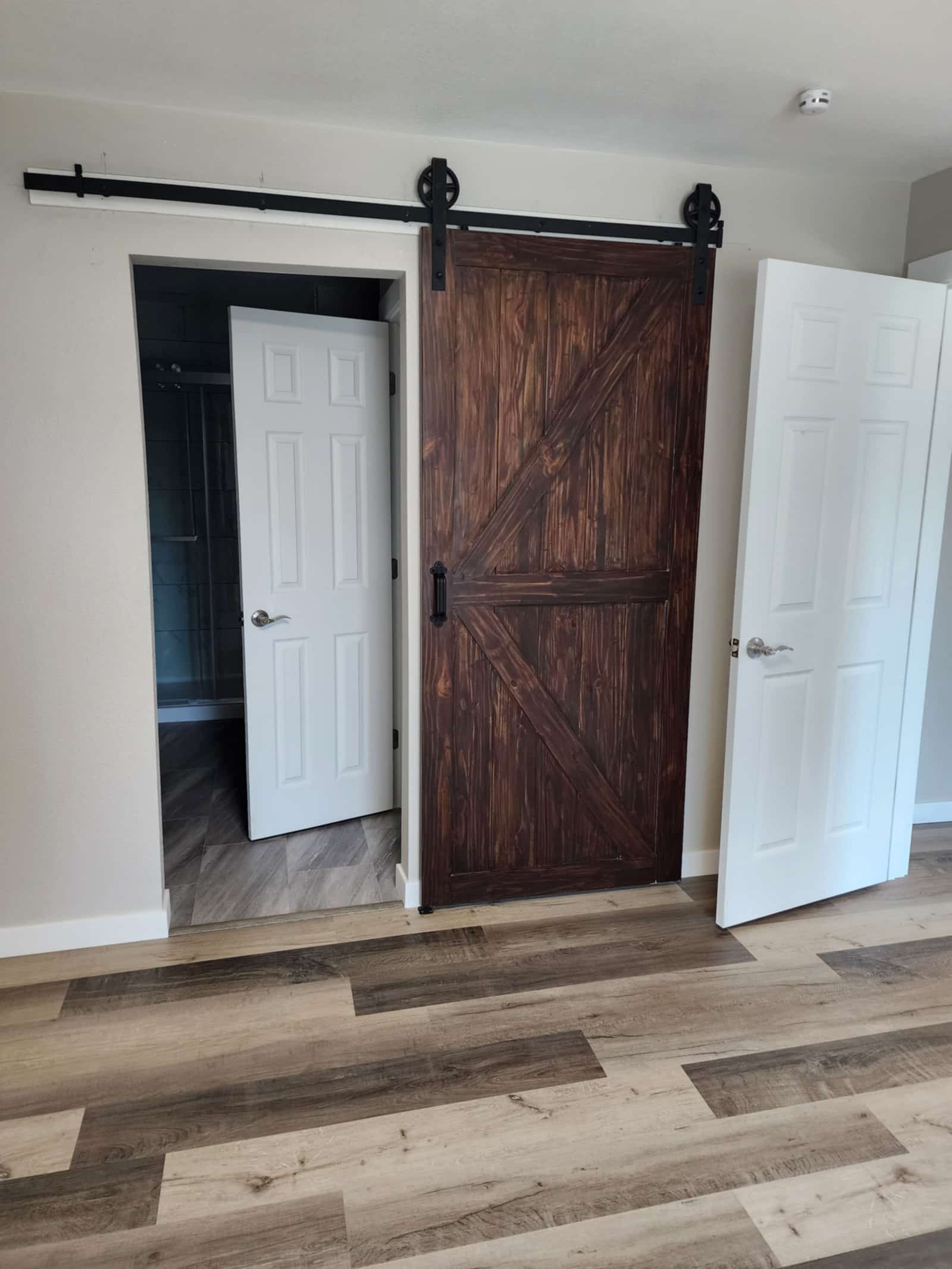 Dark timber barn-style sliding door set against a white interior wall