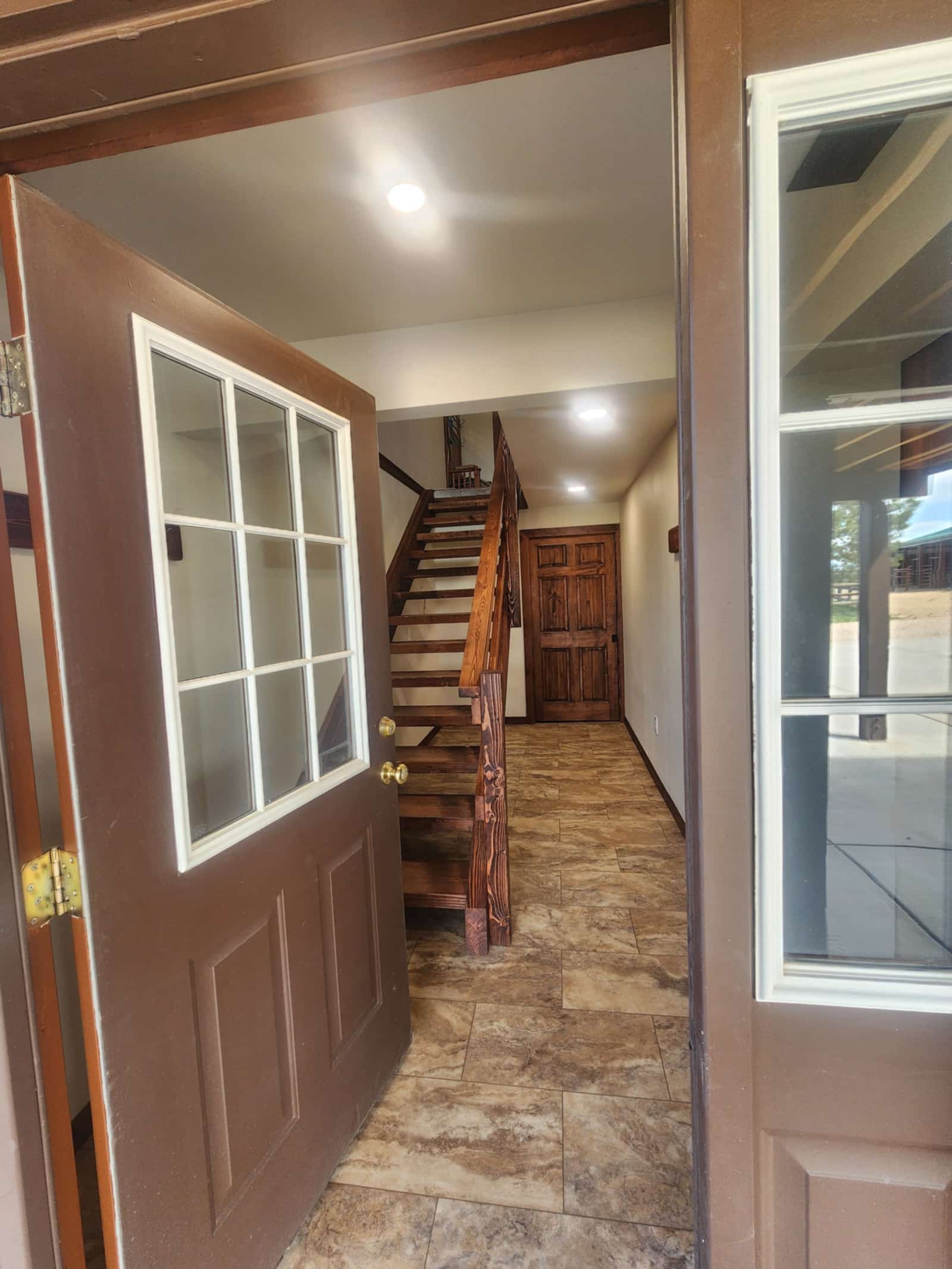 Timber staircase seen through a glazed interior door, with warm wood flooring
