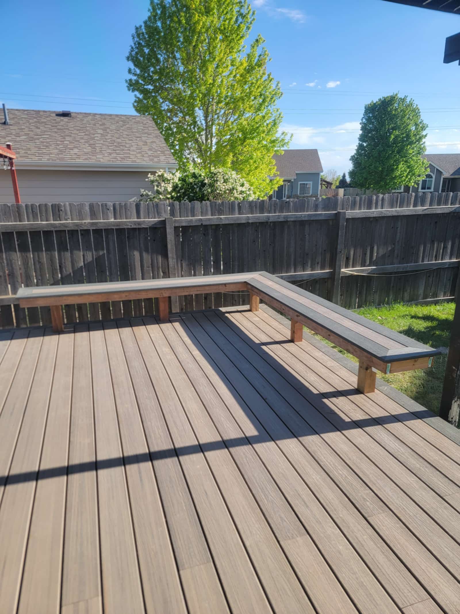 Two-tone composite deck with a long built-in bench running along its edge