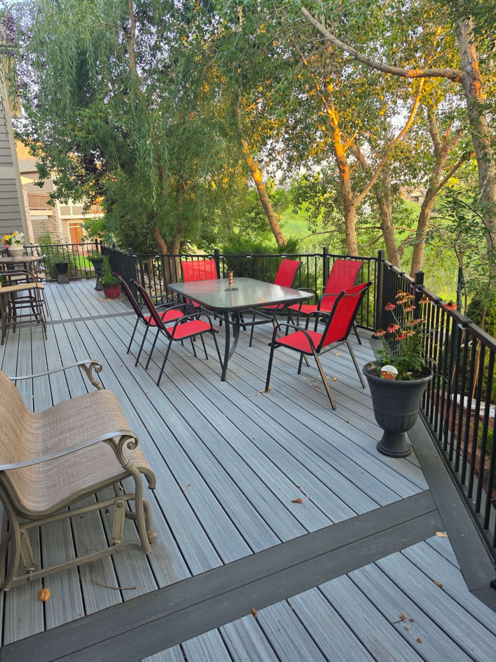 Gray composite deck with black metal railings looking out to trees