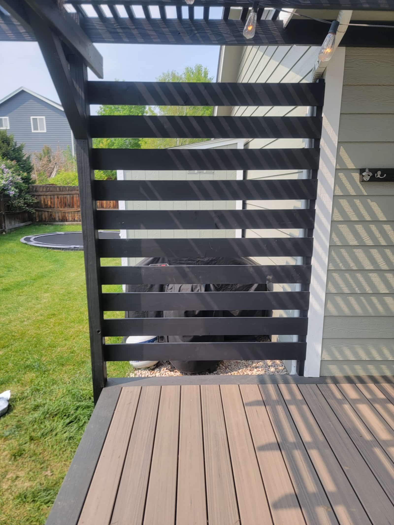 Close view of a black horizontal slat privacy screen, showing the even spacing between boards