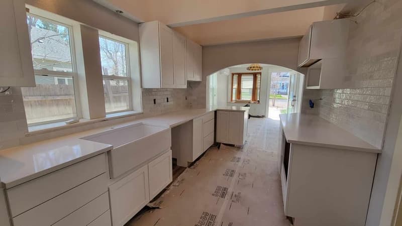 The same kitchen from the other end, with a farmhouse sink under the window, before final finishing