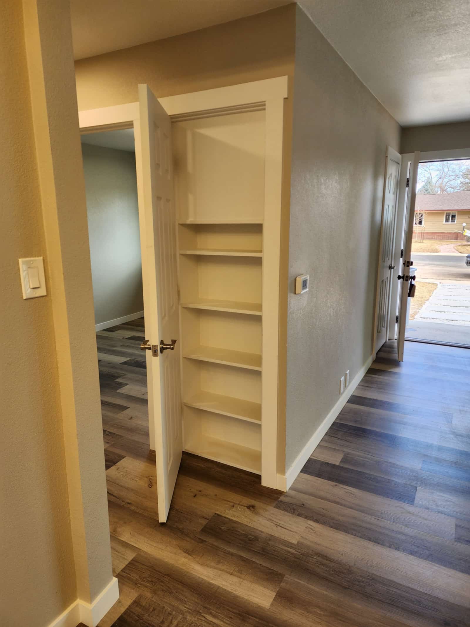 Built-in linen closet with fitted timber shelving, doors hung and trimmed